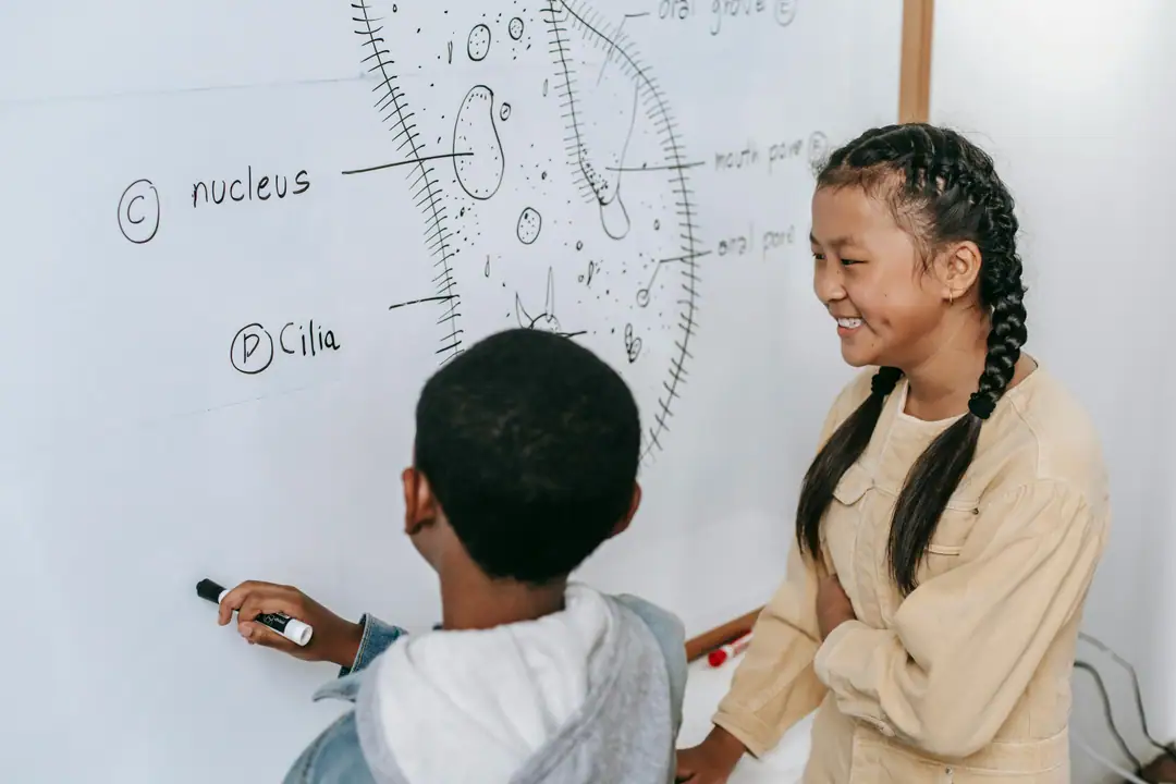 Teacher helping a young camper with a hands-on craft activity